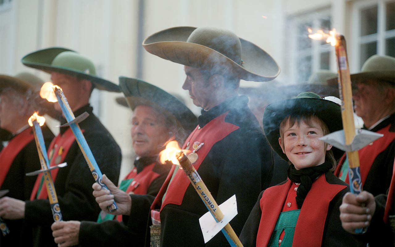 Sfilata tradizionale dell'Alto Adige e persone con candele in mano