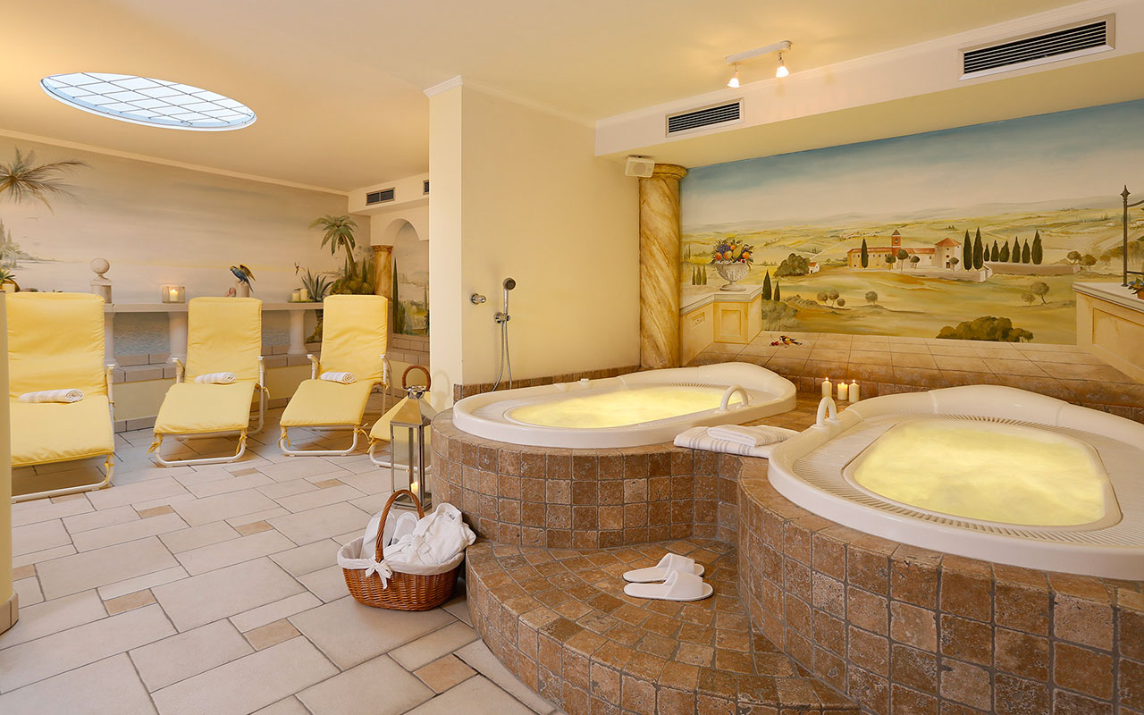 Zona wellness con due vasche idromassaggio e lettini sdraio all'Hotel Kristall vicino Merano