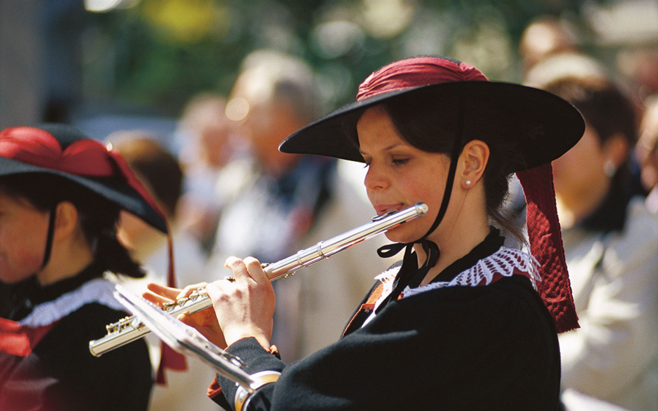 Ragazza in costume altoatesino suona il flauto