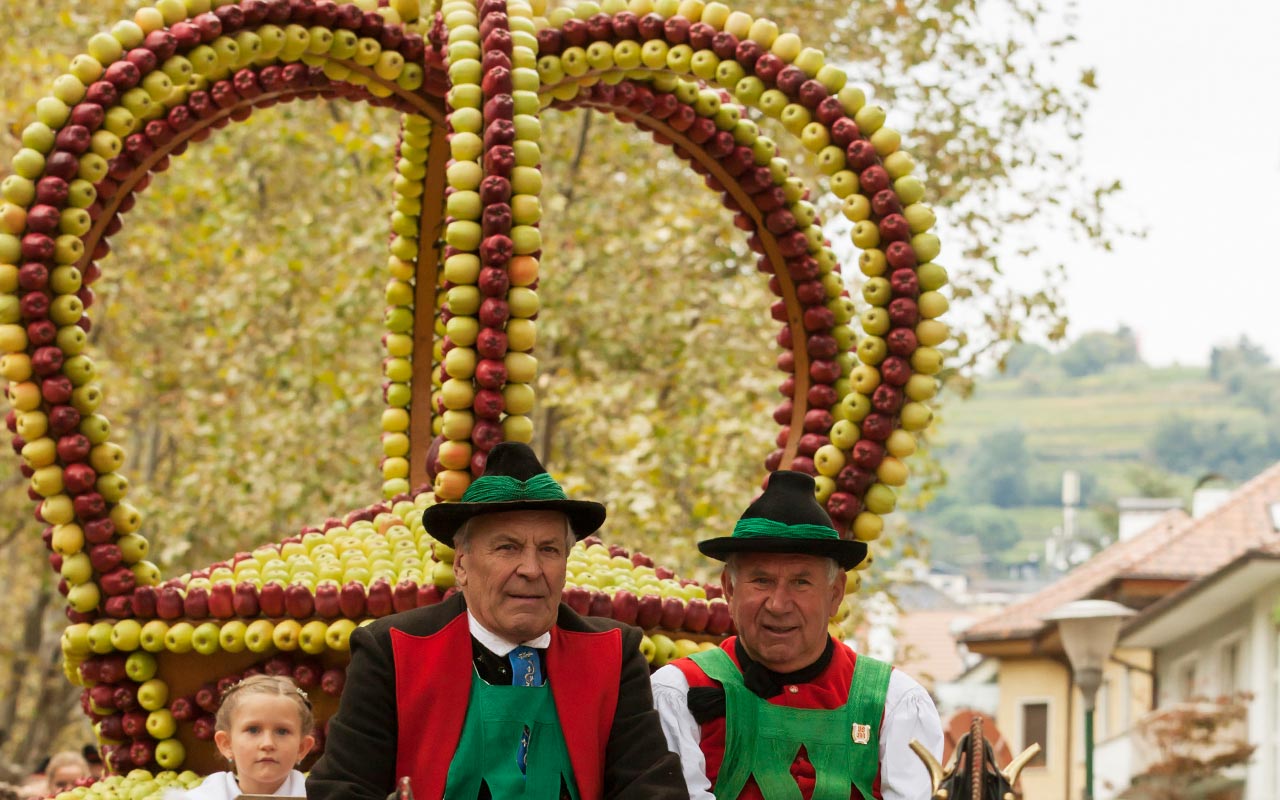 Es ist eine große Krone die aus Äpfeln besteht zu sehen und im Hintergrund befinden sich Berge