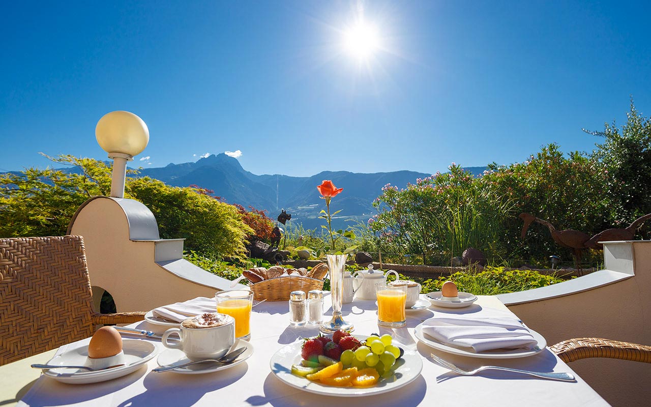 Tavolo esterno apparecchiato per la colazione all'Hotel Kristall in una giornata di sole