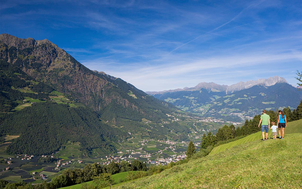 Paar spaziert auf einem Wiesenweg in der Umgebung von Meran